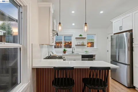 a kitchen with stainless steel appliances a sink stove and cabinets
