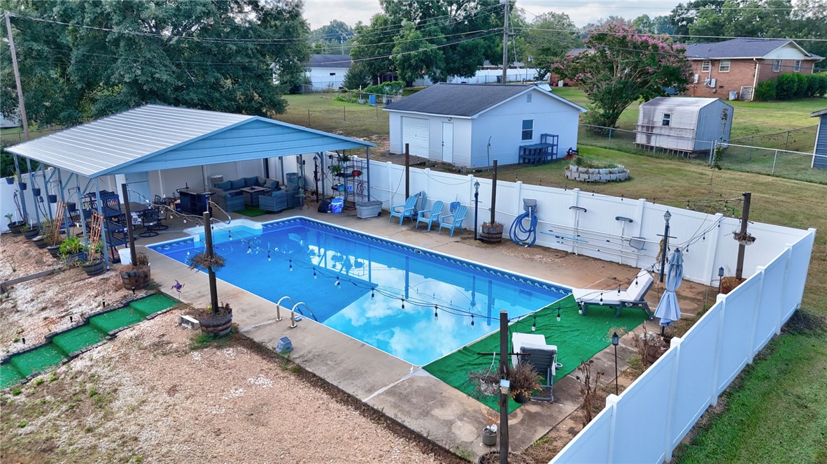 121 Wilson Road Anderson, SC 29625 - Photo 38 of 40 An inviting swimming pool area sits enclosed by fencing, featuring an adjacent covered patio structure.