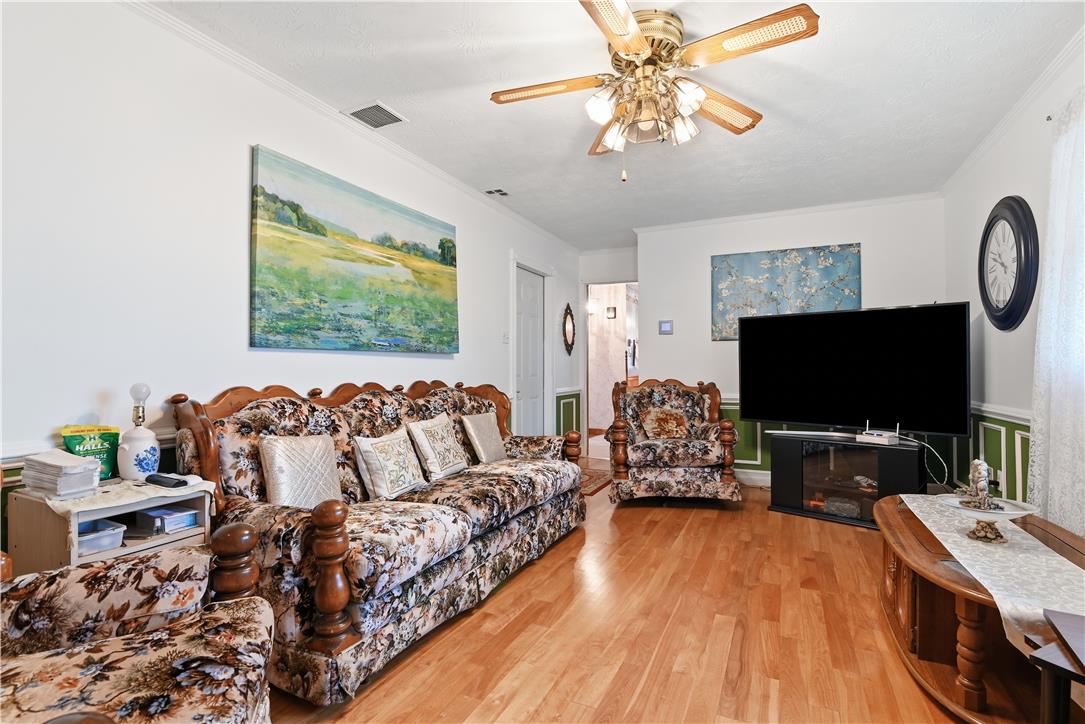 3303 Barklay Road Whitehall, PA 18052 - Photo 14 of 31 Hardwood floors and a detailed ceiling fan enhance this cozy living room space.