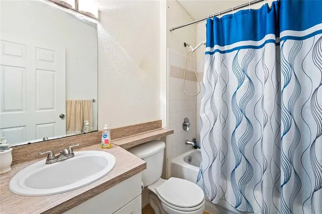 a bathroom with a sink vanity mirror and toilet