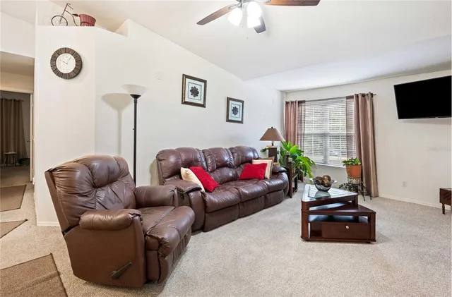 a living room with furniture a flat screen tv and a window