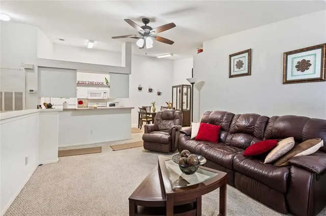 a living room with furniture and a view of kitchen