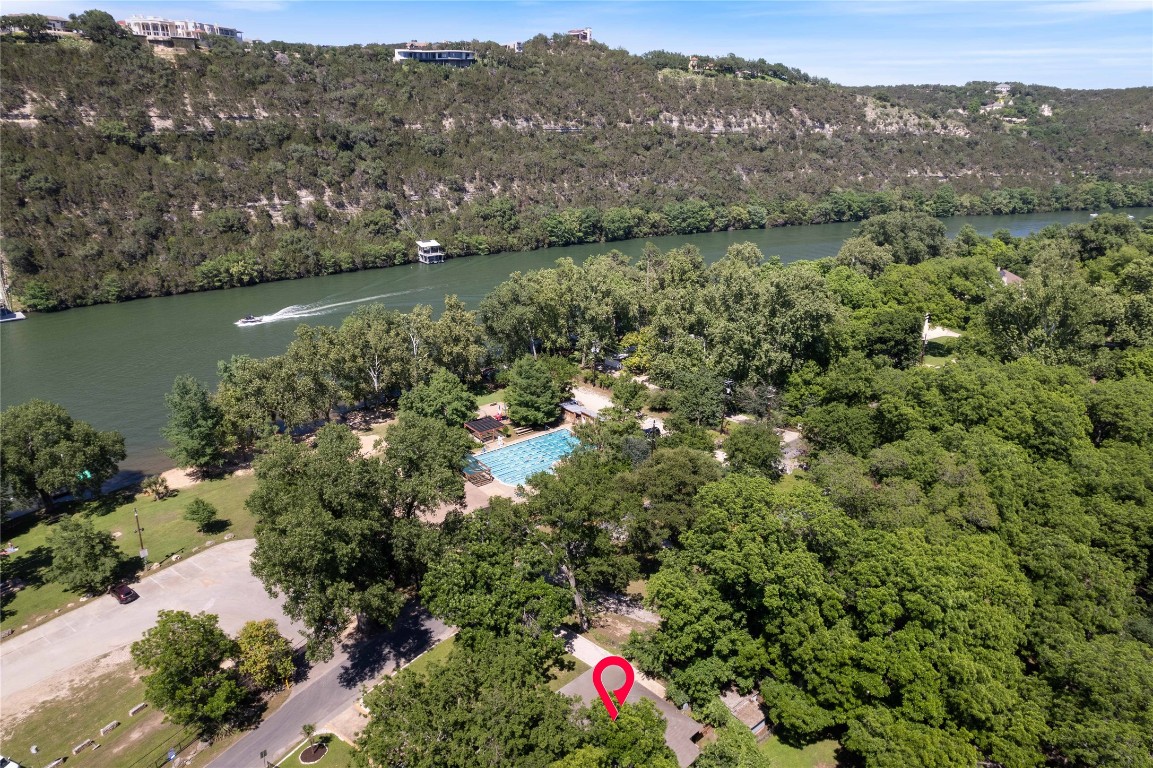 an aerial view of green landscape with trees houses and lake view