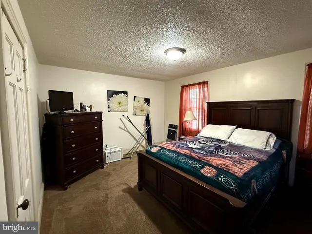 a bed sitting in a bedroom next to a window with tv