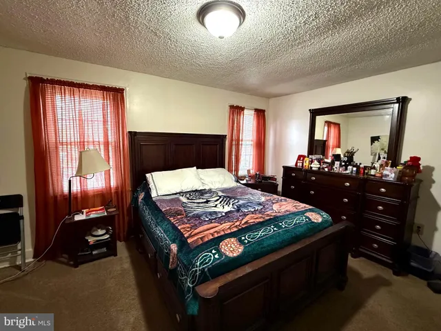 a bedroom with a bed and large windows