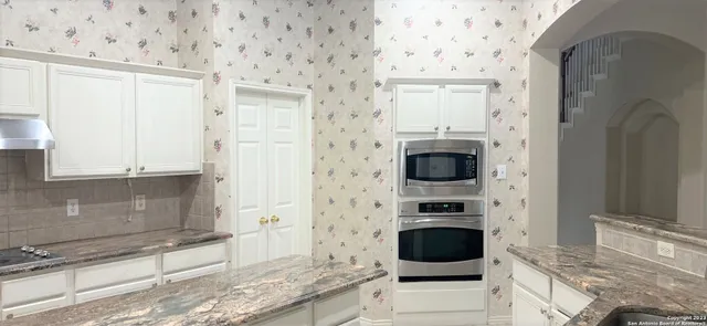 a view of a kitchen with a sink and cabinets
