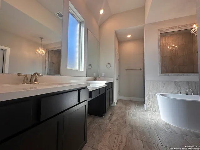 a bathroom with a double vanity sink a mirror and a bathtub