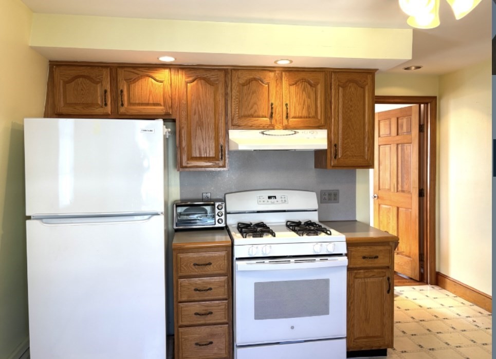 55 Port Norfolk Street, Unit 3 Boston, MA 02122 - Photo 5 of 15 a kitchen with appliances a refrigerator and a window