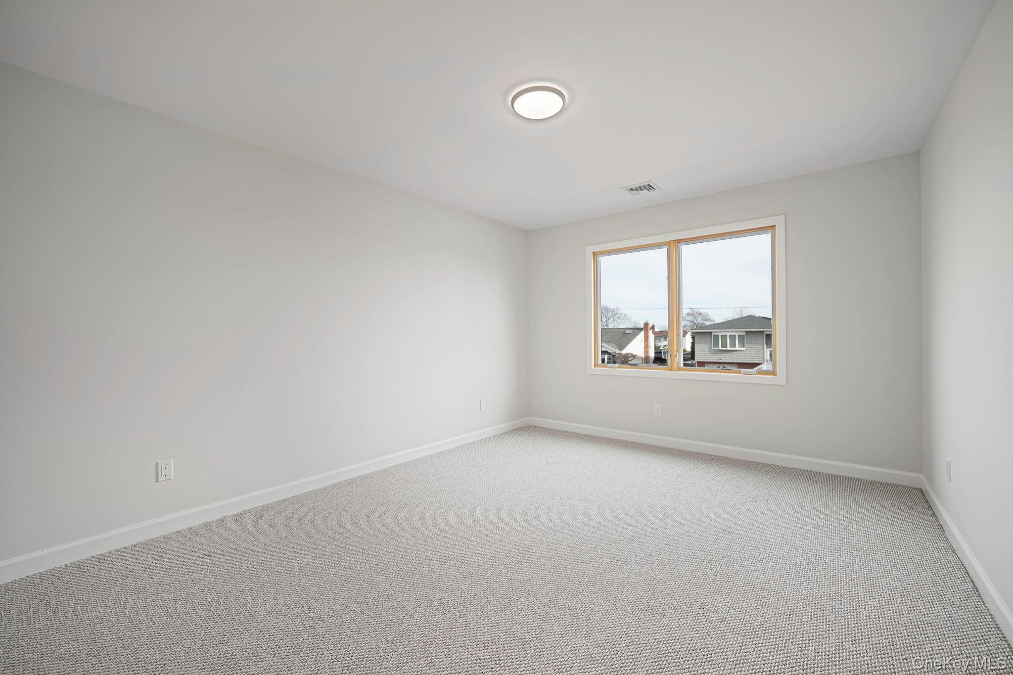 115 Riviera Parkway Lindenhurst, NY 11757 - Photo 14 of 33 Empty room with carpet and baseboards