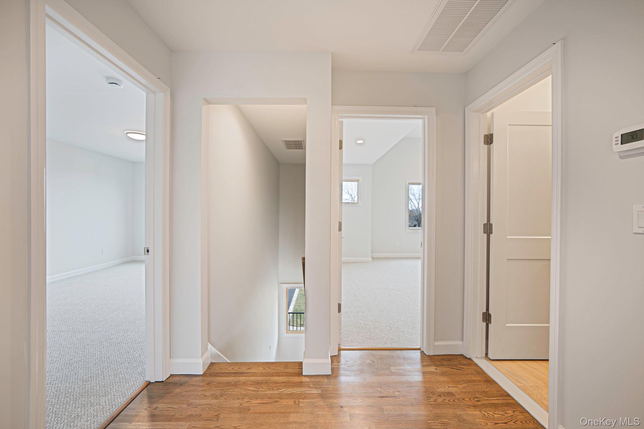 115 Riviera Parkway Lindenhurst, NY 11757 - Photo 19 of 33 Hall featuring wood finished floors and an upstairs landing