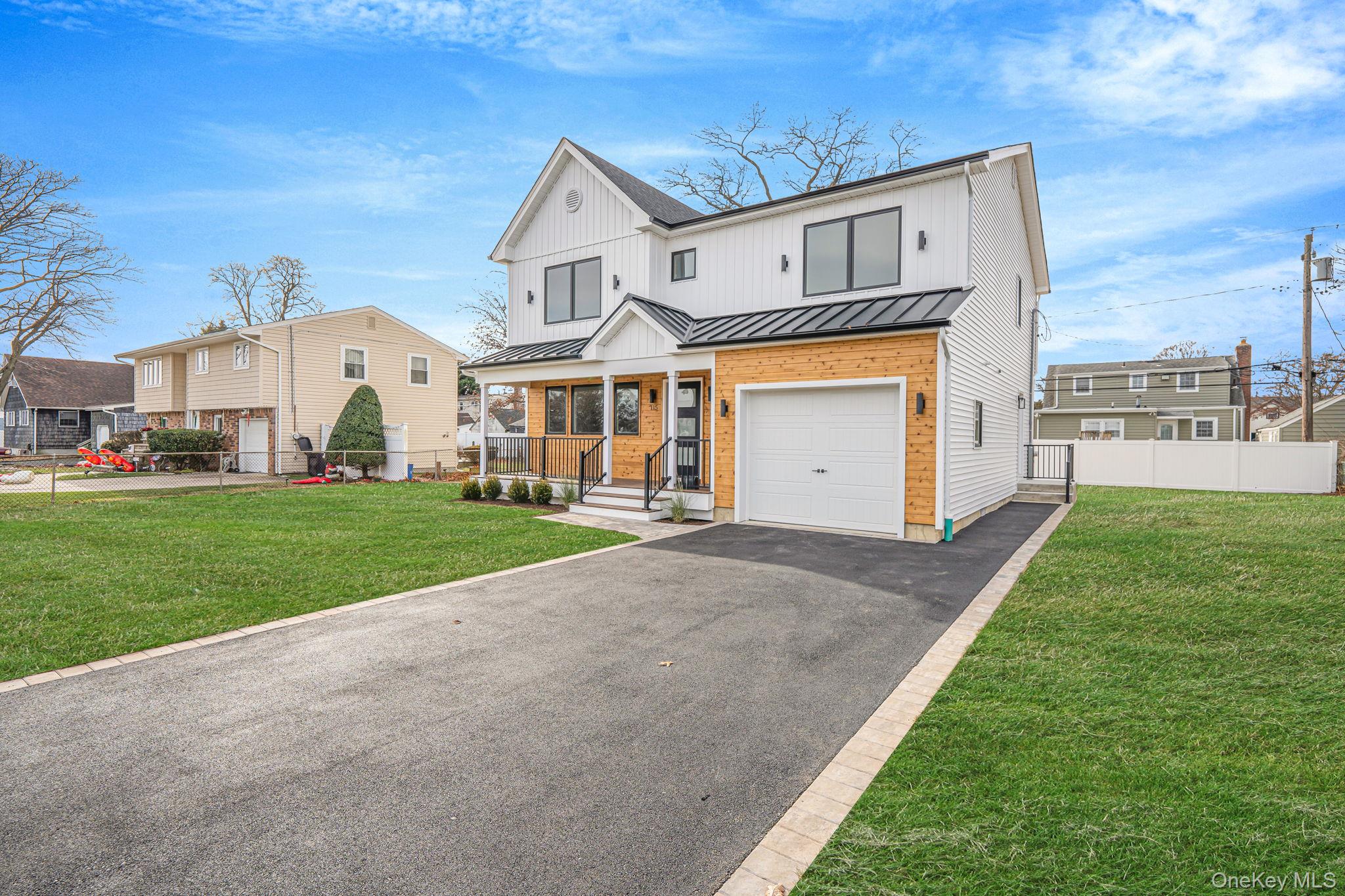 115 Riviera Parkway Lindenhurst, NY 11757 - Photo 2 of 33 Modern farmhouse with a standing seam roof, a metal roof, driveway, an attached garage, and brick siding