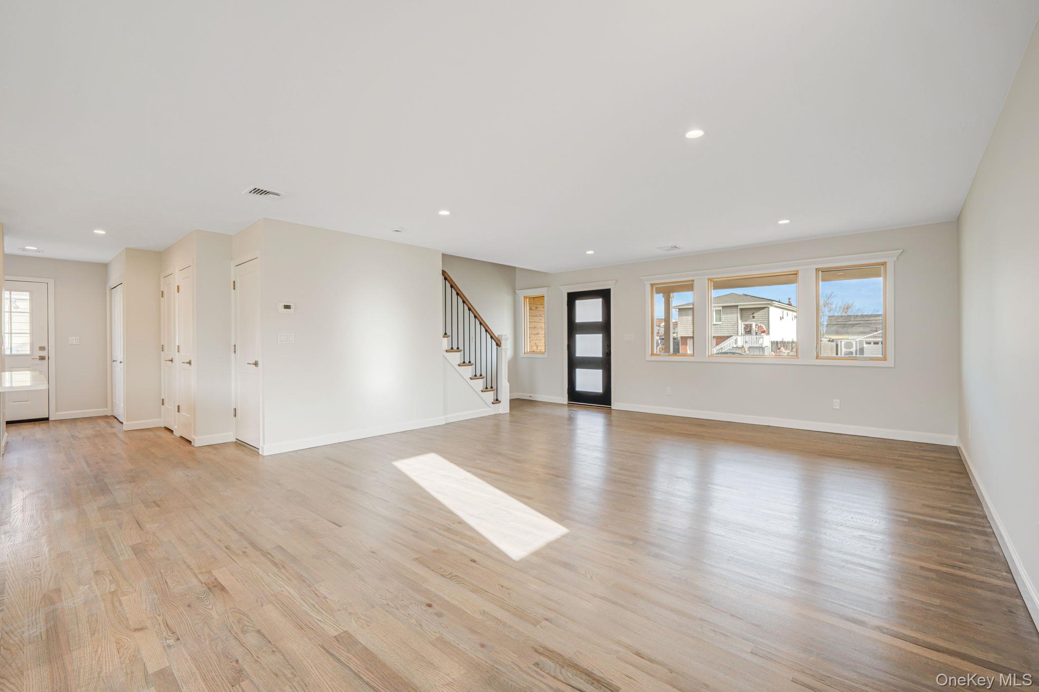 115 Riviera Parkway Lindenhurst, NY 11757 - Photo 27 of 33 Unfurnished living room featuring light wood-style flooring, stairway, and recessed lighting
