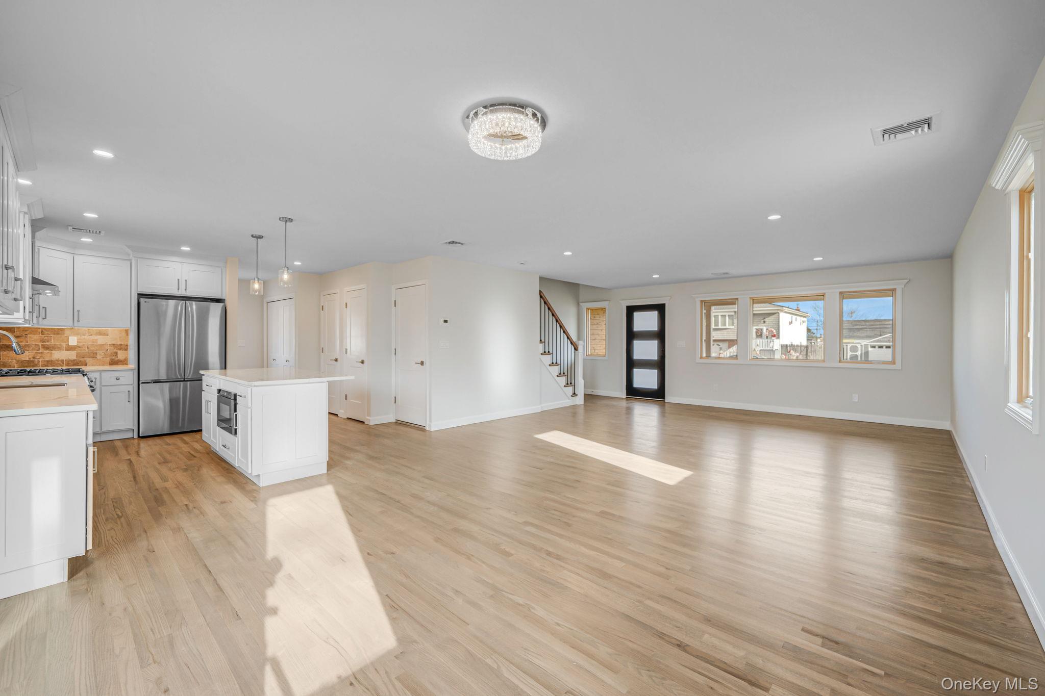 115 Riviera Parkway Lindenhurst, NY 11757 - Photo 28 of 33 Unfurnished living room with stairway, recessed lighting, and light wood-type flooring