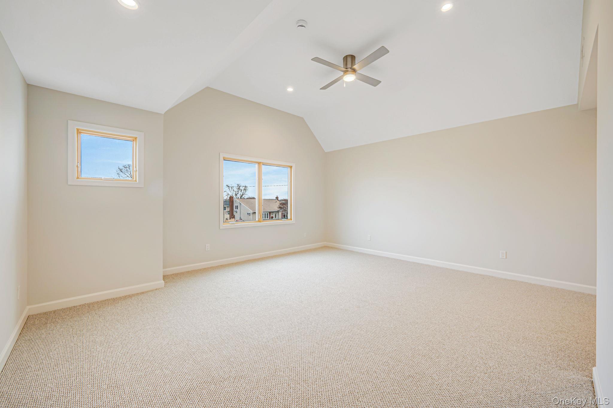 115 Riviera Parkway Lindenhurst, NY 11757 - Photo 9 of 33 Spare room featuring light colored carpet, a ceiling fan, lofted ceiling, and recessed lighting