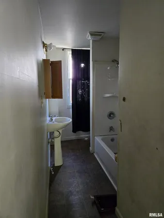 a bathroom with a tub sink and mirror