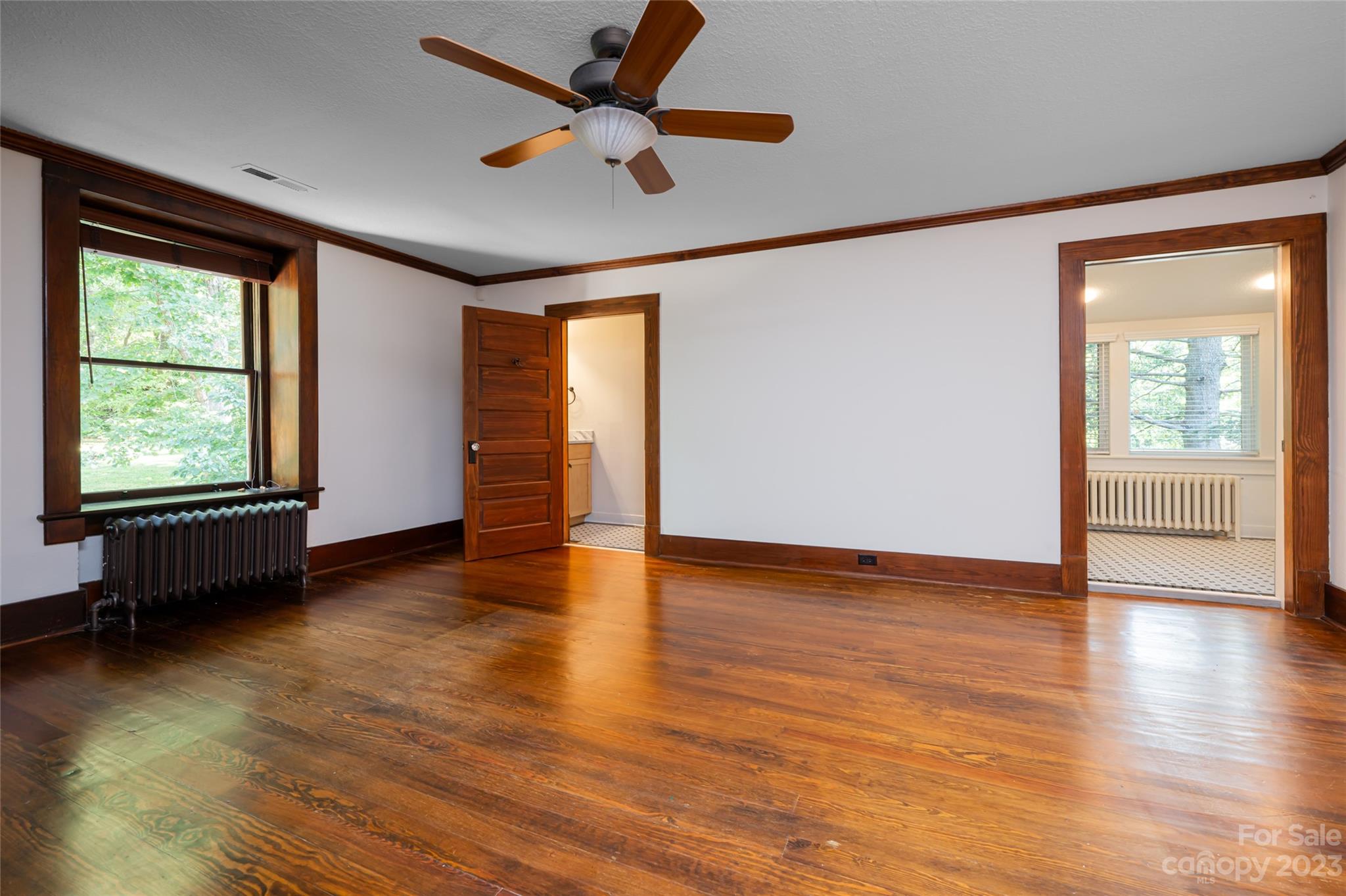 27 Edgewood Road Asheville, NC 28804 - Photo 30 of 48 an empty room with wooden floor and windows with curtains