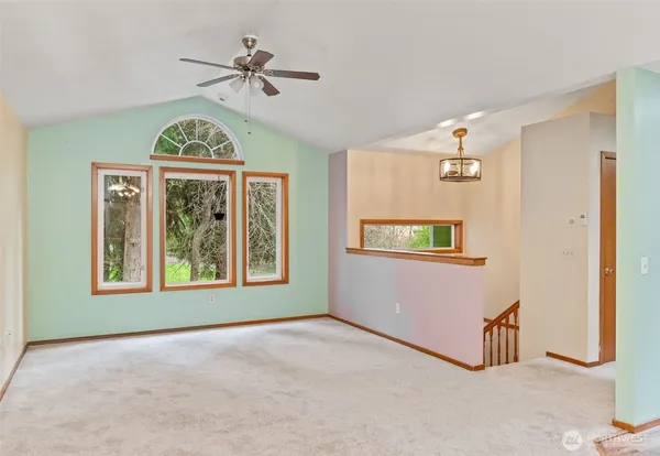 an empty room with windows and fan