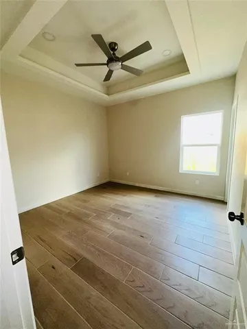 a view of a livingroom with a ceiling fan and wooden floor