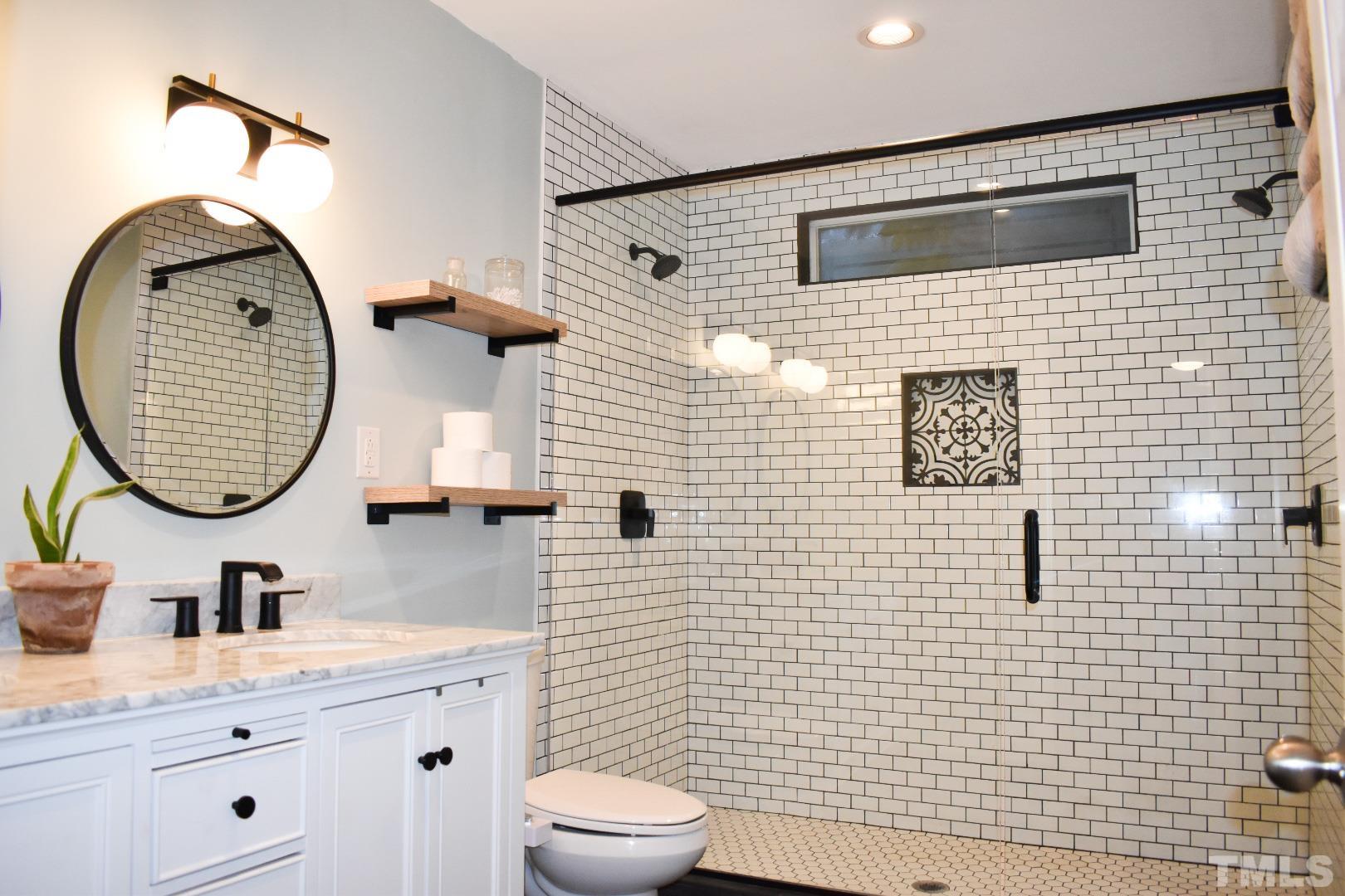 224 Glascock Street Raleigh, NC 27604 - Photo 4 of 28 a bathroom with a toilet sink vanity tub and mirror