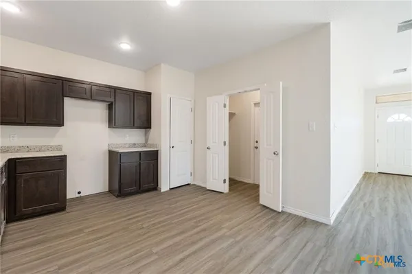 a view of a kitchen with electric appliances and wooden floor