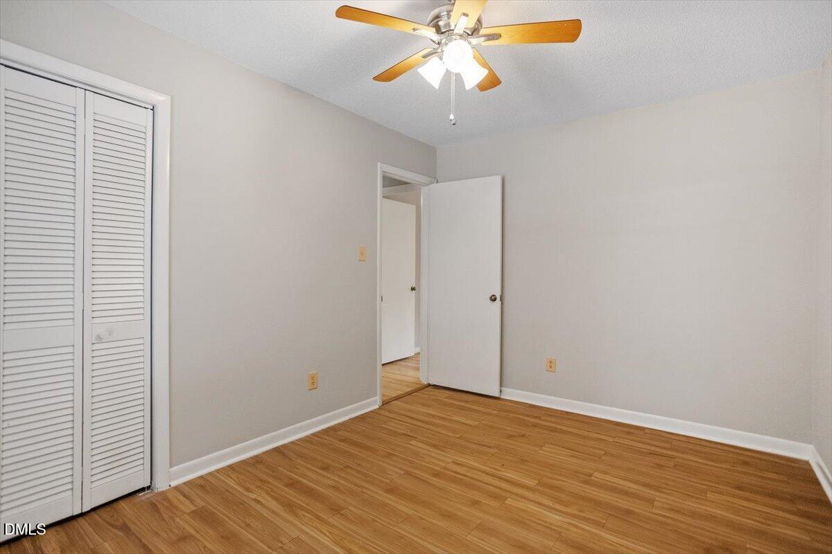 1405 Fairway Ridge Drive Raleigh, NC 27606 - Photo 19 of 27 an empty room with wooden floor fan and windows