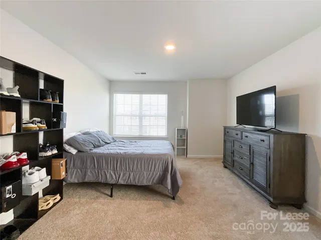 a bedroom with furniture and a flat screen tv