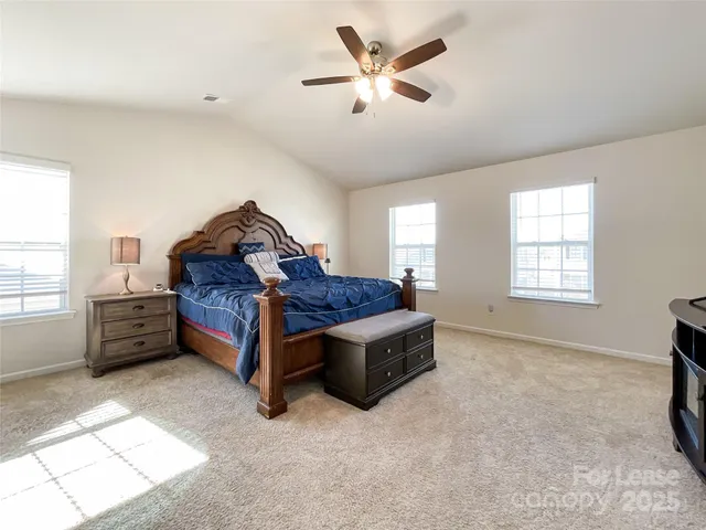 a spacious bedroom with a bed and a chandelier