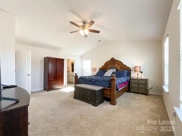 a spacious bedroom with a bed and a chandelier