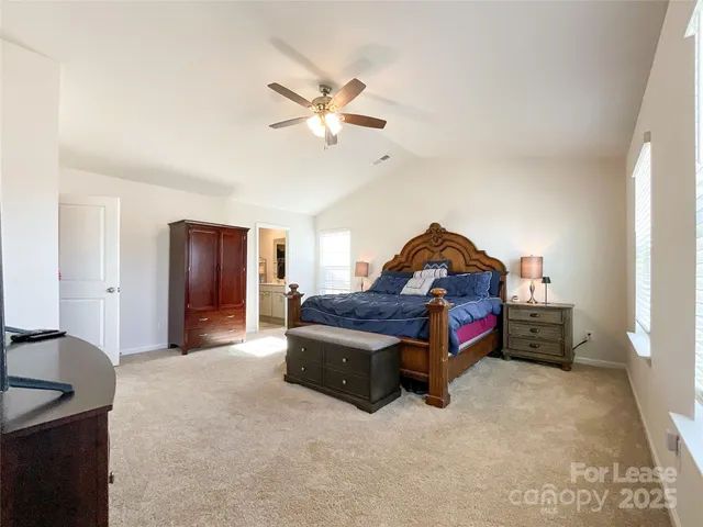 a spacious bedroom with a bed and a chandelier