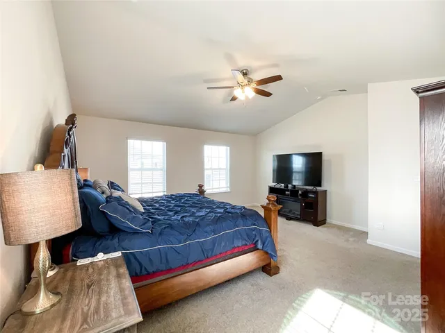 a bedroom with bed and a flat tv screen on a dresser