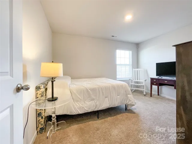a bedroom with a bed table and chair