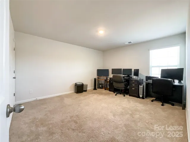an empty room with furniture and a flat screen tv
