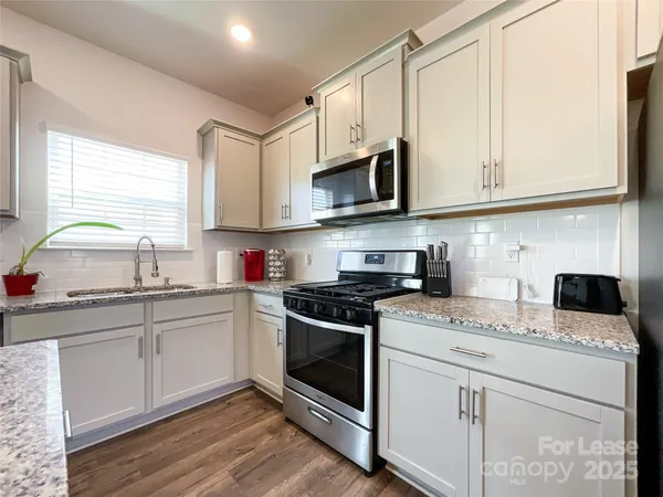 a kitchen with stainless steel appliances granite countertop a sink and a stove
