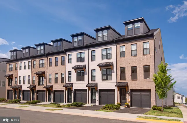 a front view of a residential apartment building with a yard