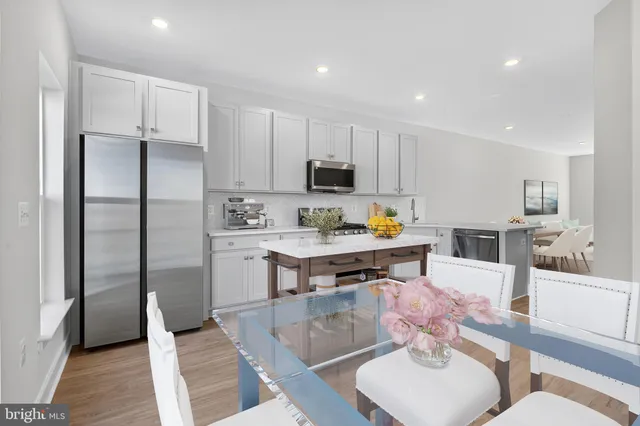 a kitchen with stainless steel appliances granite countertop a refrigerator and a stove top oven
