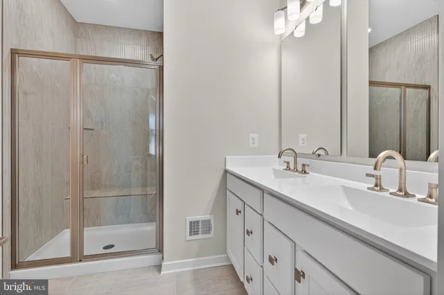 a bathroom with a double vanity sink mirror and shower