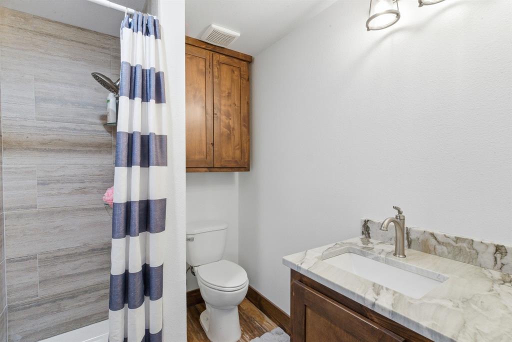 330 Chism Trail Gordon, TX 76453 - Photo 12 of 35 a bathroom with a granite countertop sink toilet and mirror