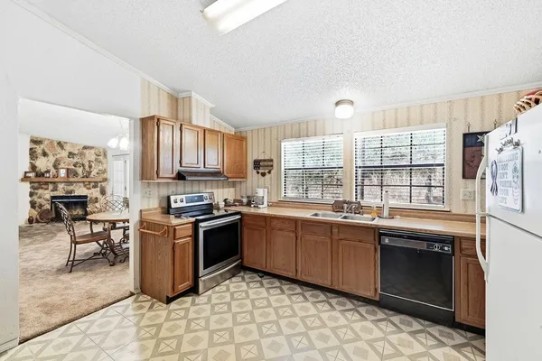 a kitchen with stainless steel appliances granite countertop a stove sink and cabinets