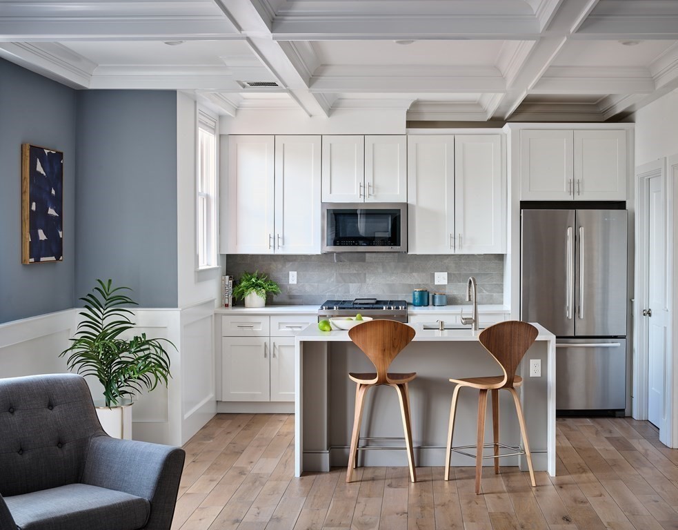 42 Bow Street, Unit 2 Somerville, MA 02143 - Photo 4 of 14 a kitchen with stainless steel appliances granite countertop a stove a refrigerator a microwave a sink and white cabinets