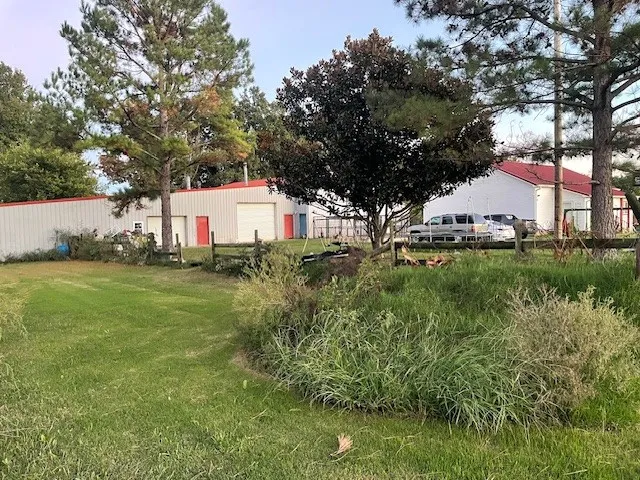 a sign that is sitting in the grass next to a house