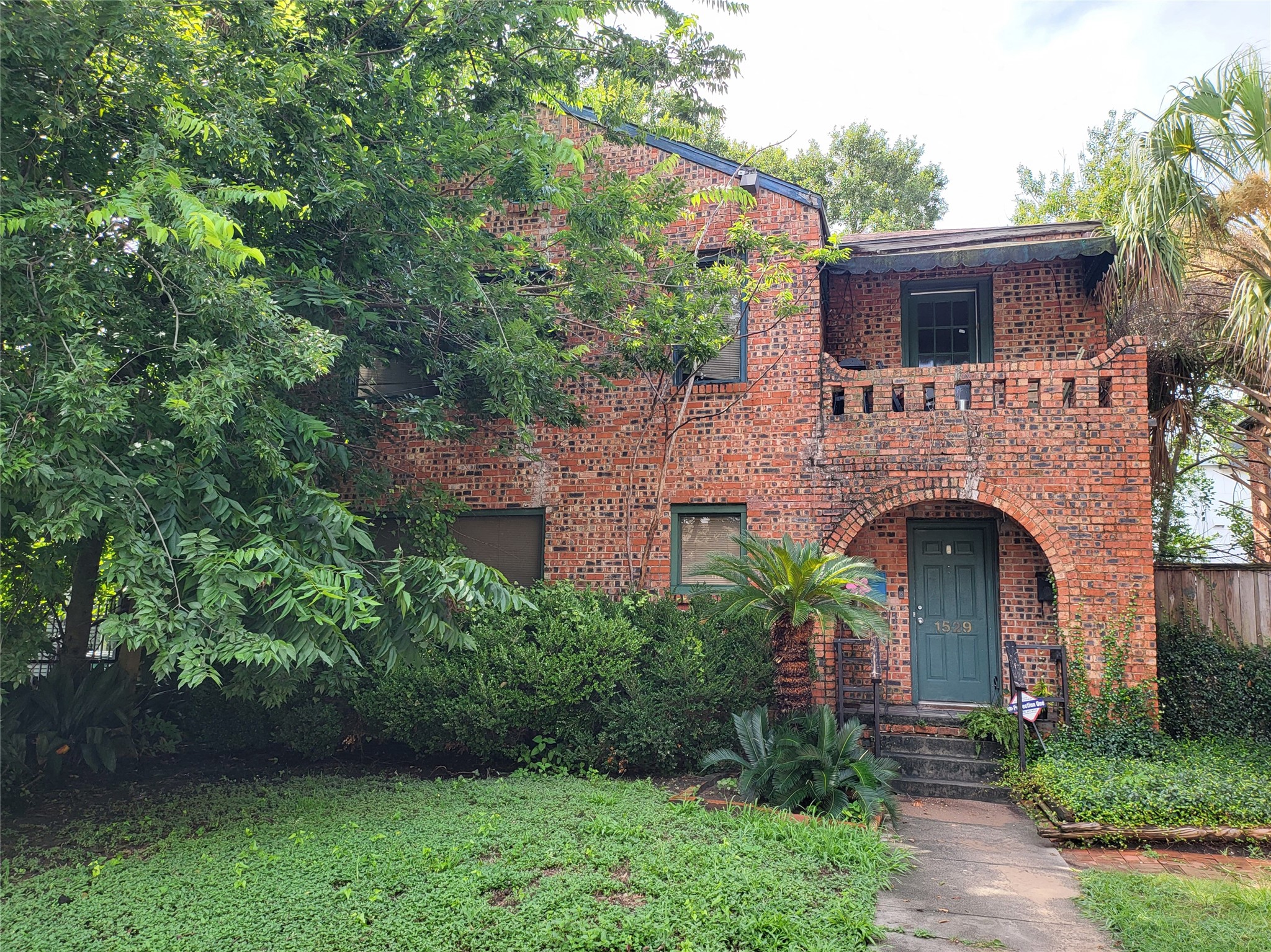 a front view of a house with plants and garden