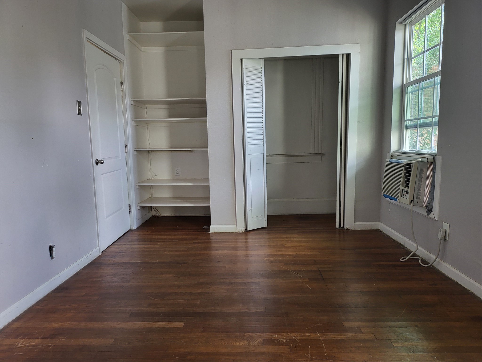1529 Welch Street Houston, TX 77006 - Photo 25 of 34 a view of an empty room with wooden floor and a window