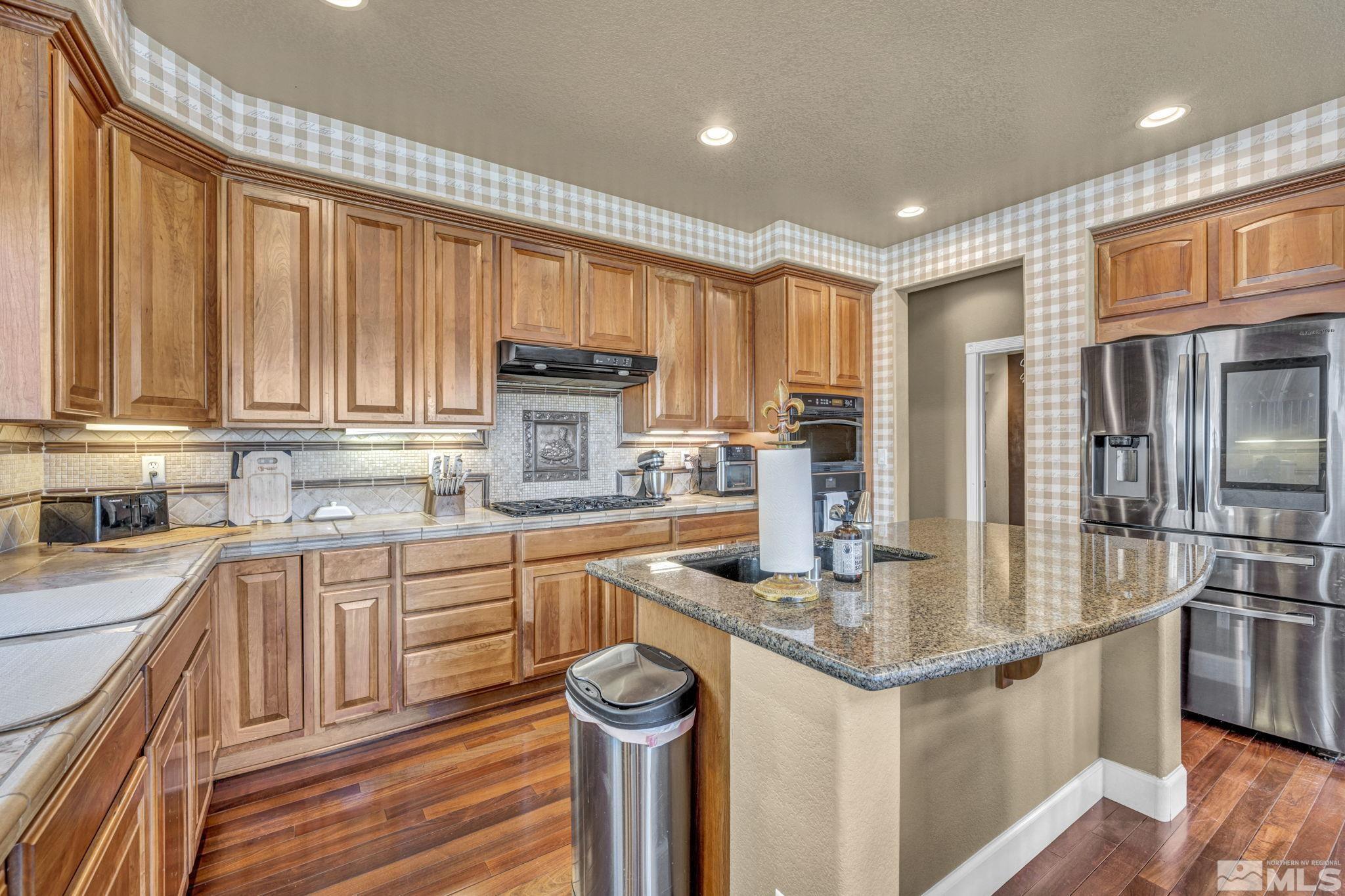 2713 Robb Drive Reno, NV 89523 - Photo 4 of 39 a kitchen with stainless steel appliances granite countertop a refrigerator a stove top oven a sink and dishwasher