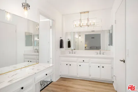 a bathroom with a sink double vanity granite tub shower and a mirror