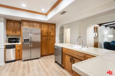 a kitchen with stainless steel appliances granite countertop a refrigerator a sink a stove and island