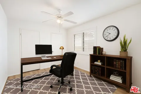 a view of a workspace with furniture and a window