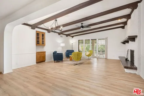 a view of a livingroom with wooden floor and furniture
