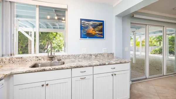 a bathroom with a granite countertop sink and a window