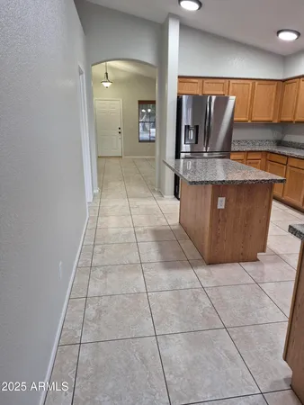 a kitchen with granite countertop a sink a counter top space cabinets and a window