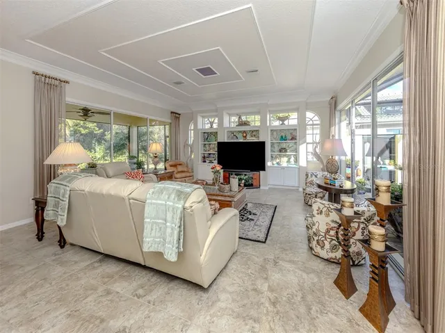 a dining room with furniture a flat screen tv and a floor to ceiling window